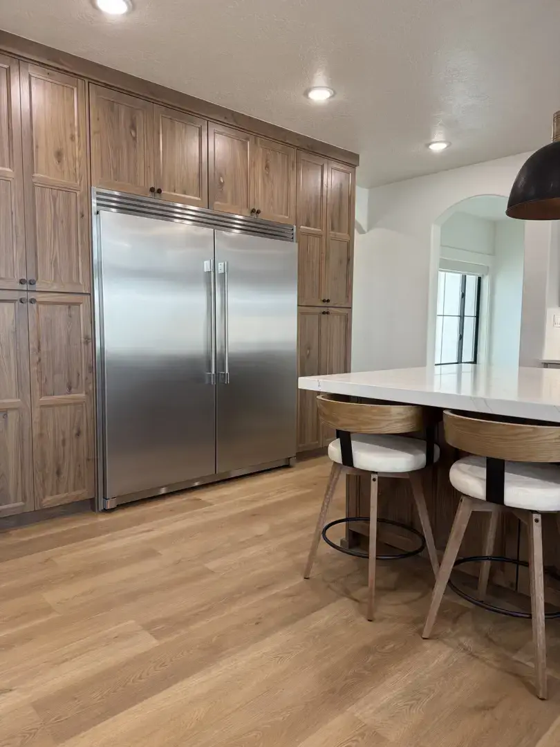 Dream Home Cabinetry: Olsen Project kitchen with custom wood cabinets and stainless steel refrigerator in Slaterville, Utah.